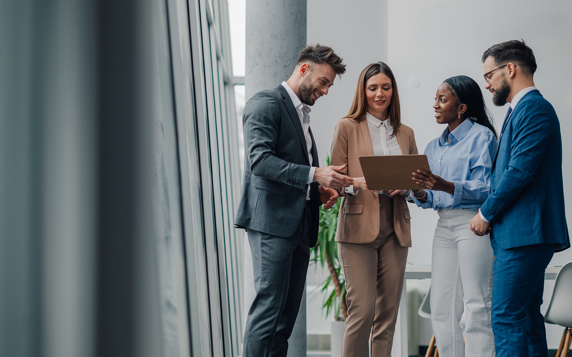 Business Team Analyzing Data On Tablet In Modern Office